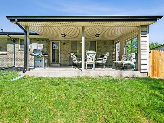 Covered patio including furniture, natural gas grill, and an electric smoker