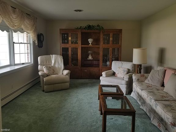 Spacious front room with sunny bay window and plush carpet.
