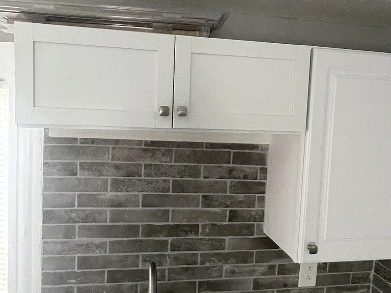 New kitchen counter, new sink, new cabinets, with tile backsplash
