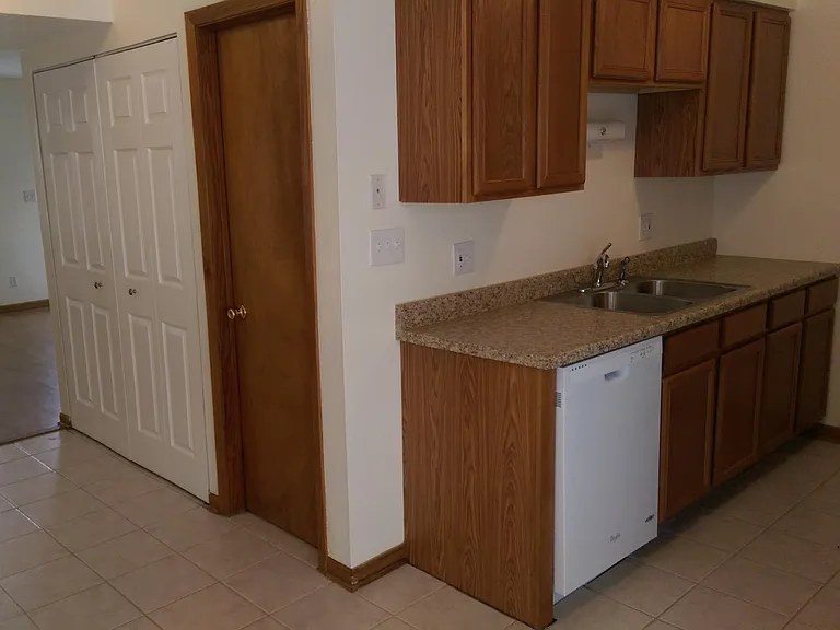 View of kitchen, half-bath door, and laundry room doors