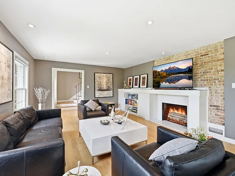 Main living room with tons of windows, built in shelving, and cozy fireplace.
