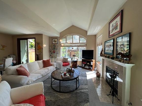 Living Room has Cathedral Ceilings, Fireplace, abundant natural light, access to back private patio.