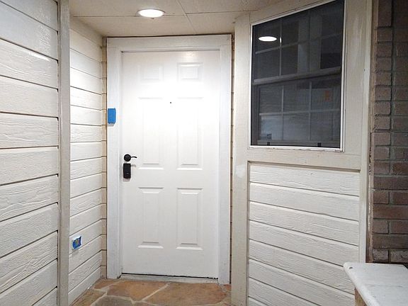 Covered entrance, stone patio with stone bench, keeps package deliveries dry and safe.