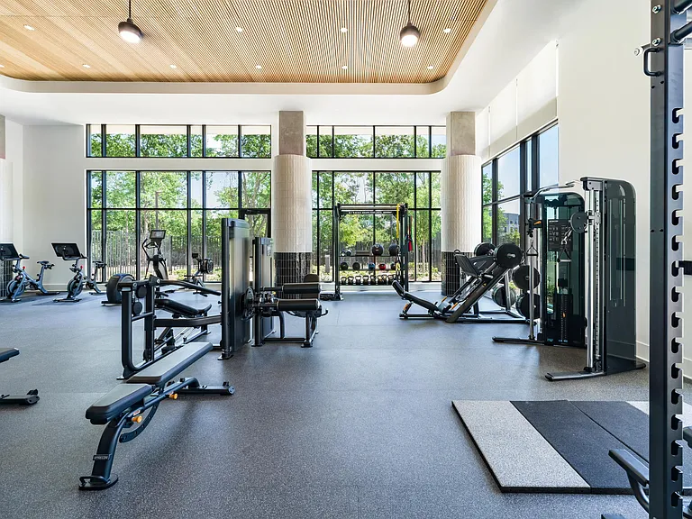 Light-filled fitness studio with strength equipment, open floor space, and natural light supporting focused workouts and daily training routines.