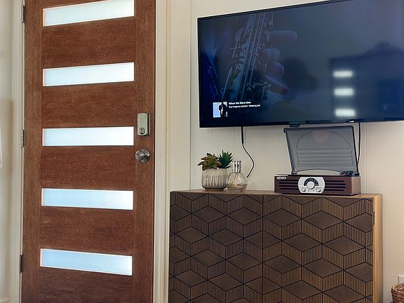 Front door and living room TV/vintage record player with records for your enjoyment.