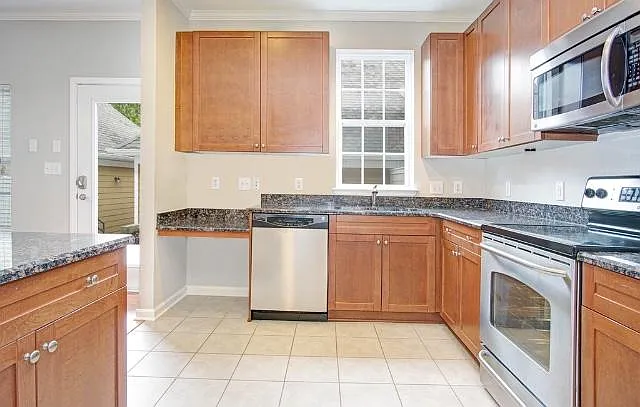 Kitchen with granite and stainless steel, tile floor. Backdoor.