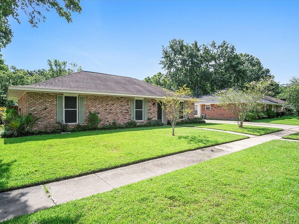 Front of house with long driveway to covered carport.