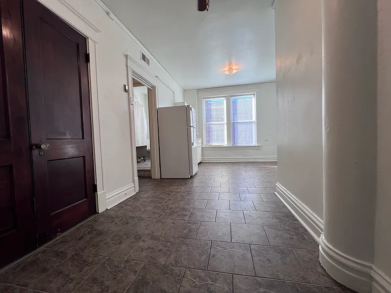 Soaring ceilings and oversized windows fill this expansive living space with natural light, while original trim details add a touch of historic character throughout.