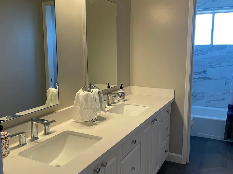 Double sink leading to bath with shower