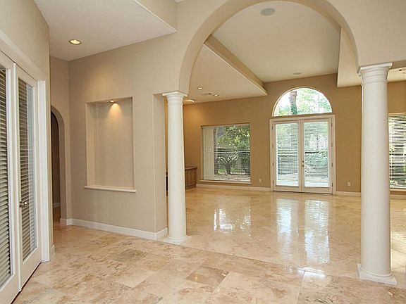 This custom home has arched entryways, recessed lights and neautral paint throughout. Two columns le
