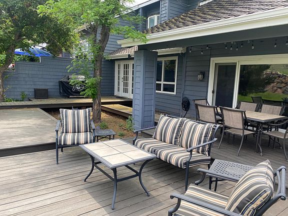 View of patio deck with chairs, table for six, and grill