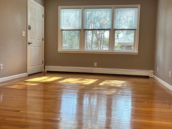 Large living room features wood floors and lots of natural light. Ceiling fan and lighting are both dimmable.