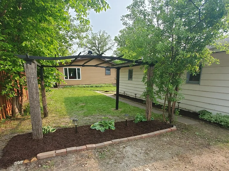 Standing in alley looking at back yard and side of two-car detached garage.