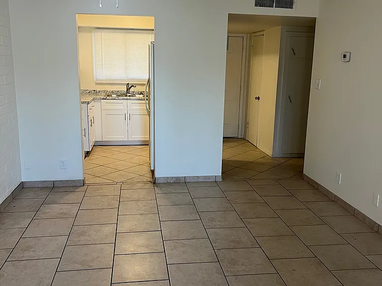 View from the living room to the kitchen, front door, and entry closet