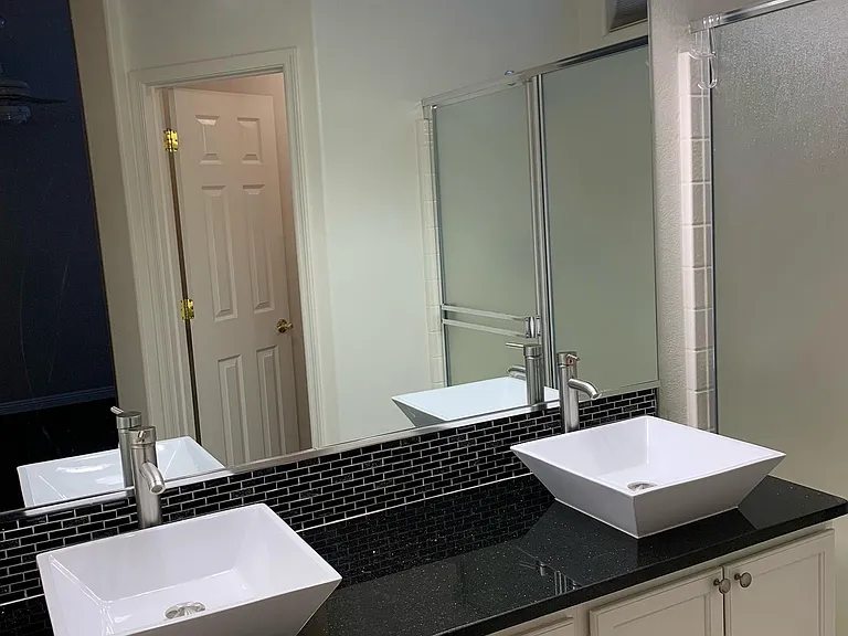 Master bathroom with dual basin sinks on granite countertop. Walk in shower.