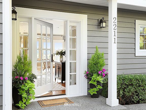 Charming cottage style door wth side-lights is the perfect entry to this Hamptons style, Mercer Island, home.