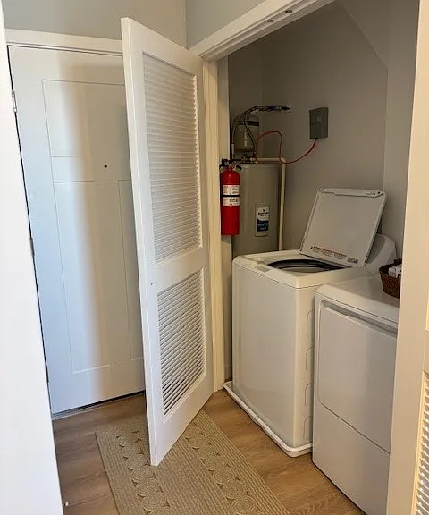 full sized washer dryer inside apartment by entrance door and kitchen.