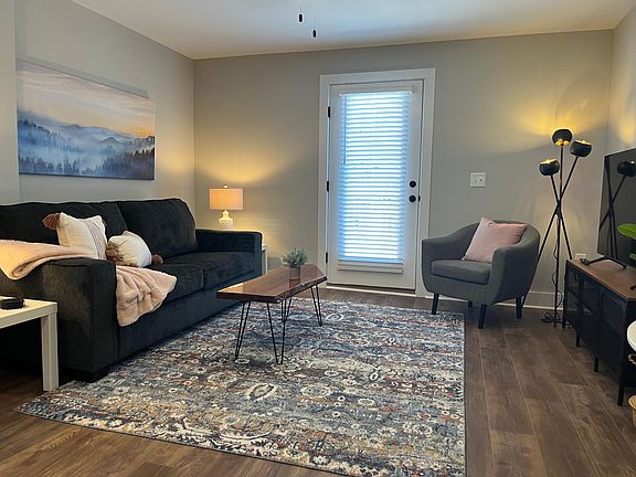 Living room open to dining, bar stools and kitchen area with large 55" TV and access to private deck with seating for 4.