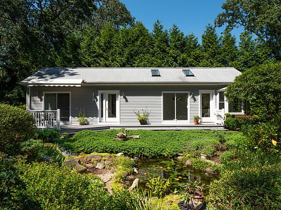 The front of the house overlooks a waterfall garden. The awning shades a deck outside of the master bedroom. Two skylights are over a living room with cathedral ceiling. Two bow windows on the right surround the kitchen & dining area. Notice two entrance