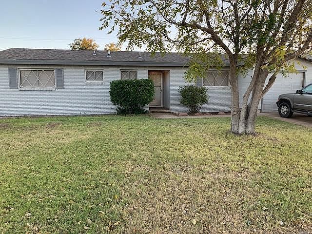 Fresh exterior paint with green lawn and shrubs give a nice curb appeal.
