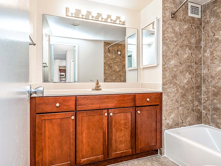 Updated bathrooms with tiled bathroom shower and tub, cherry maple vanity and premier lighting