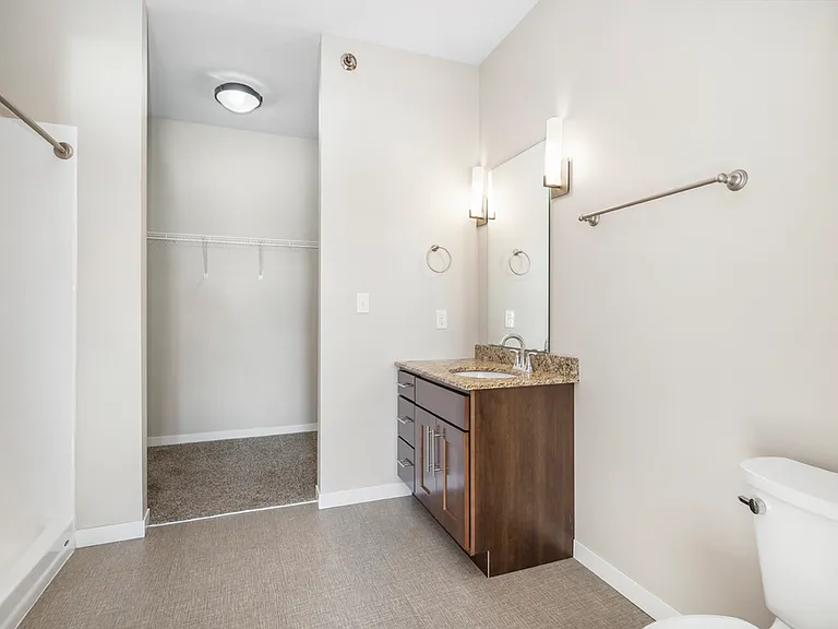 Bright and contemporary bathroom with elegant vanity and spacious walk-in closet. Bright and contemporary bathroom with elegant vanity and spacious walk-in closet.