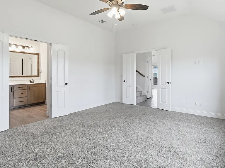 Master Bedroom featuring vaulted ceilings, light gray carpeting, and a ceiling fan