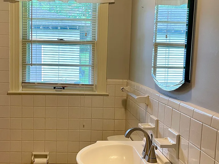 Full bath. Tub with conventional shower head that converts to handheld, closet with adjustable wire shelving, vanity, large medicine cabinet. Mosaic tile.