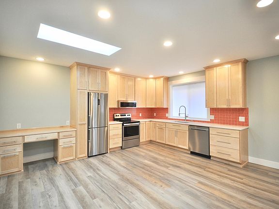 Main level: Kitchen, desk, livingroom with two skylights. Windows open to the garden that is being landscaped.