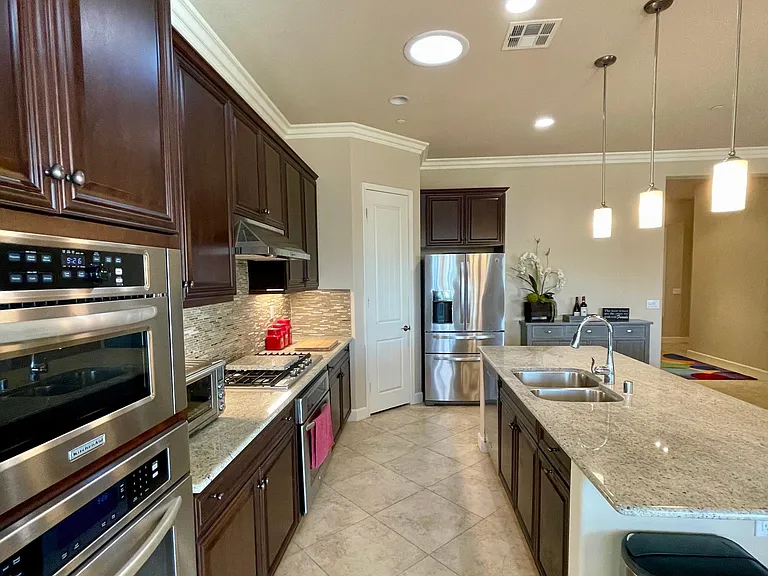 Fully stocked Chef's kitchen including quality stainless double ovens, built-in microwave, gas six-burner cooktop, Breville counter oven, vent hood, dishwasher, under-mount double basin sink and French door refrigerator all topped with granite counters.