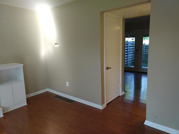 Hallway to dining area, kitchen and fenced patio with awning. Coded entry through back door. The pool is right outside the fence! Coat closet to the left and half bath to the right.