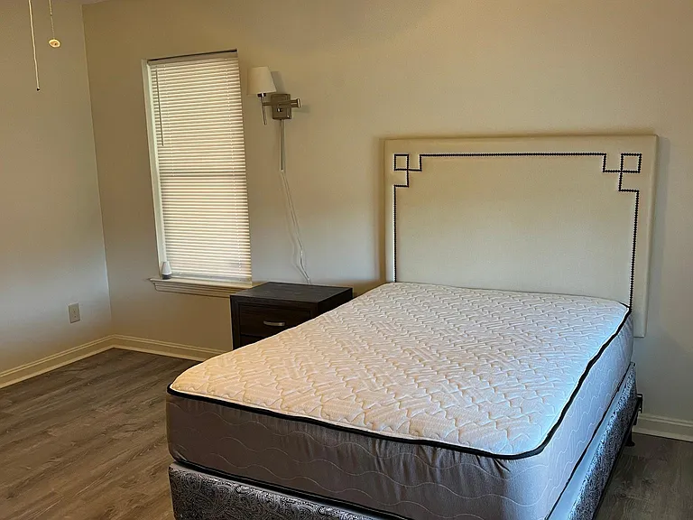 Room A - Bed and window view to side of house/car port