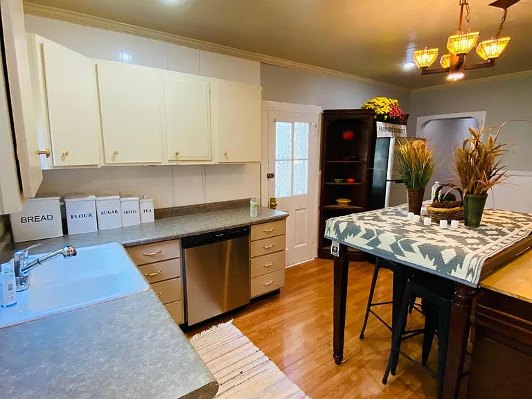 The ample counter, cabinets, porcelain farmer's sink, and stainless steel dishwasher make meals and cleaning easy!