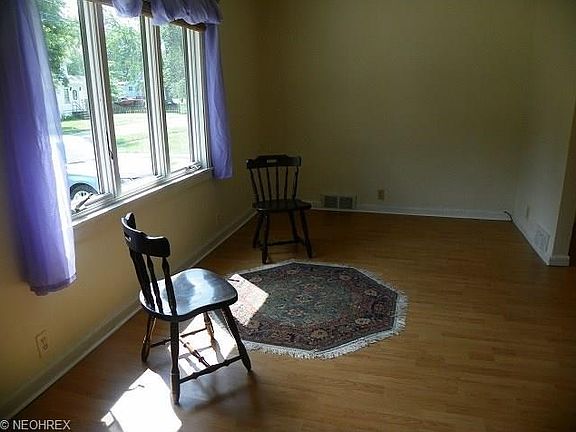 Bright and cherry living room  with newer laminate floor  and large front window with view of street