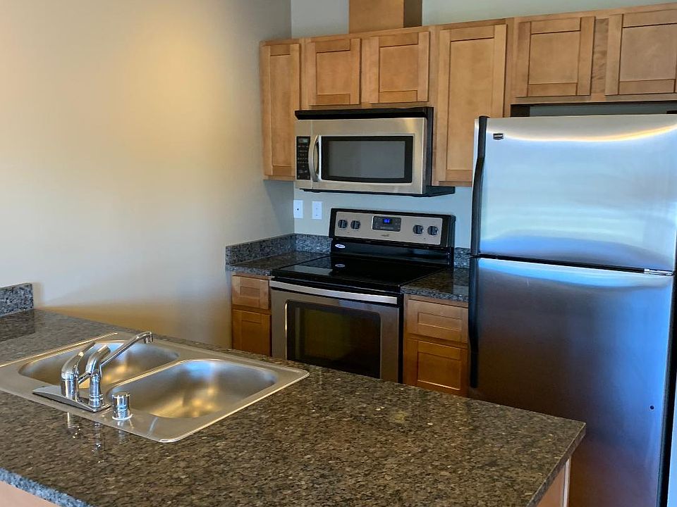 Kitchen includes dishwasher, refrigerator, ceramic-top stove and microwave.