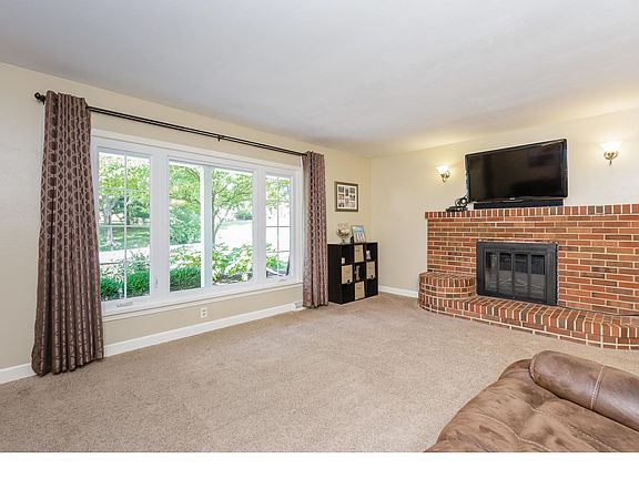 Living room with wood burning fireplace and brick surround