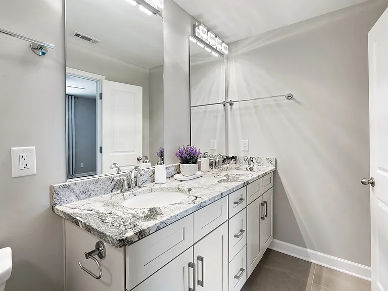 Beautifully designed primary bathroom with dual vanities and a luxurious walk-in shower.
