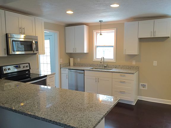 Brand new kitchen features stainless steel appliances and gr