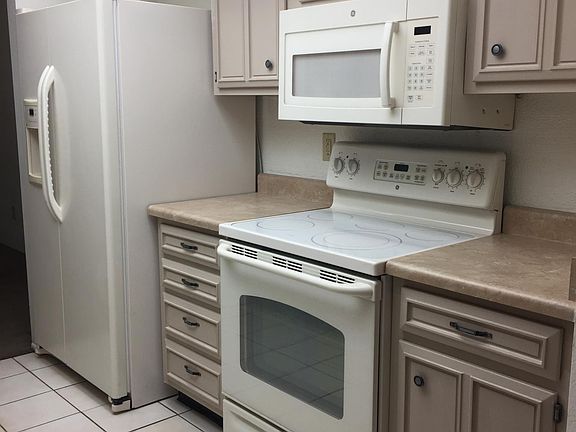 Full kitchen with updated appliances: refrigerator, glass top stove/oven, microwave, dishwasher, sink, and disposal. Refrigerator is 25.3 cu. ft. side by side with filtered water and ice dispensers on door.