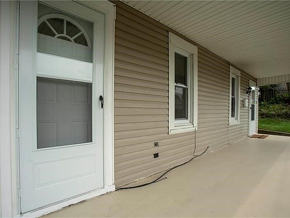 Another view of the covered front porch and new living room door.  Nicely done in white, providing great curb appeal.