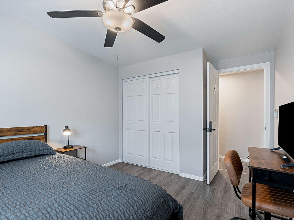 Bedroom with ceiling fan, sliding-door closet, and a dedicated desk setup for work or study.