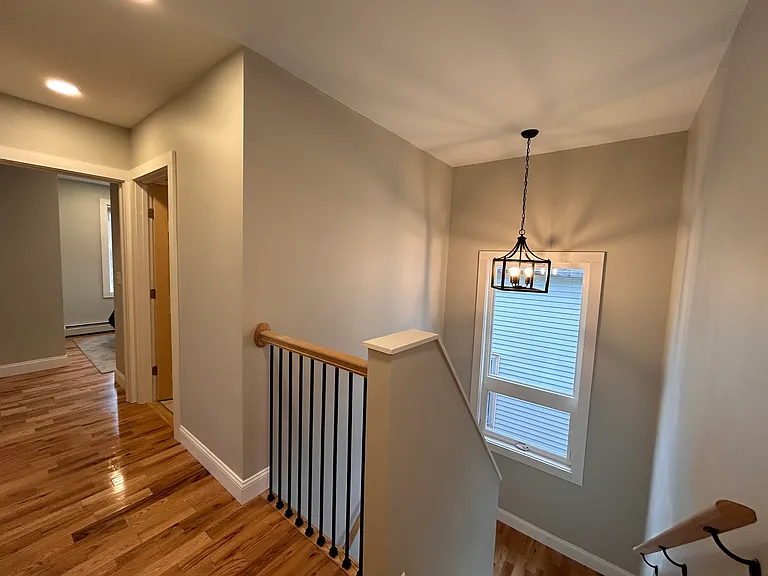 Hallway and stairs. First bedroom at end of the hall. Door next to it is general use bathroom.