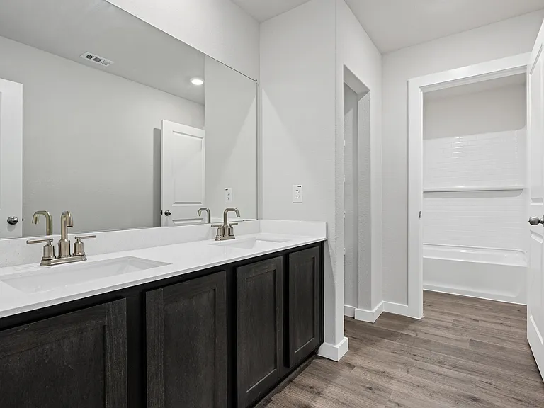 The secondary bathroom has a vanity space and a shower-tub combo.