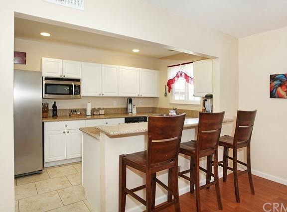 Updated Kitchen Includes Large Tile Flooring, White Cabinets, Granite Counters, Stainless Steel Appl