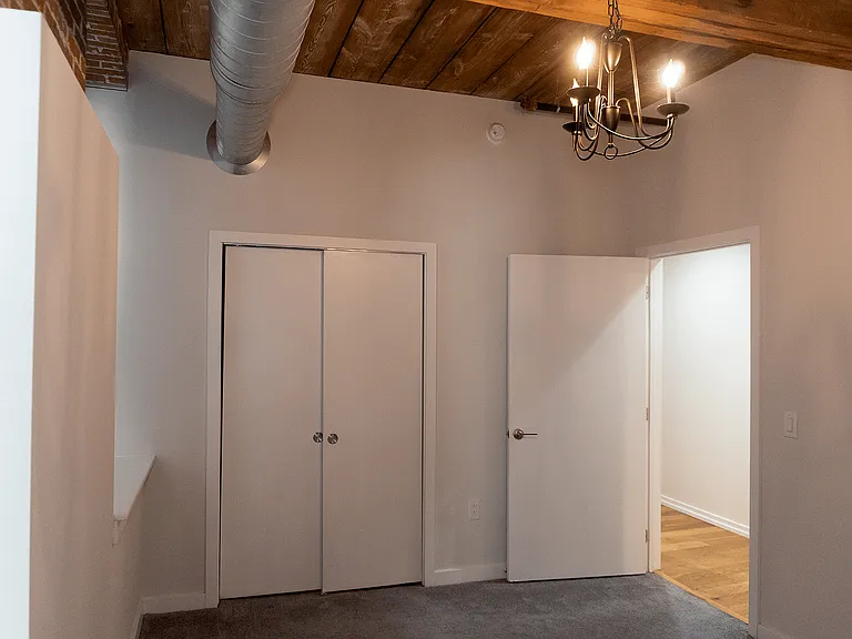 Experience modern living with this chic loft bedroom, featuring rustic ceilings and contemporary design.