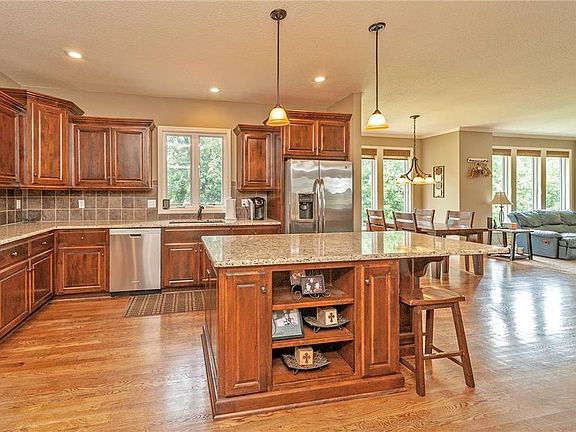 Incredible Kitchen w/Large Island, Built-in SS Cooktop, Microwave, Dishwasher, Granite, Upgraded Back-splash, Built-in's, Walk-in Pantry, Hardwood Floors, Breakfast Room, & Door to Deck!