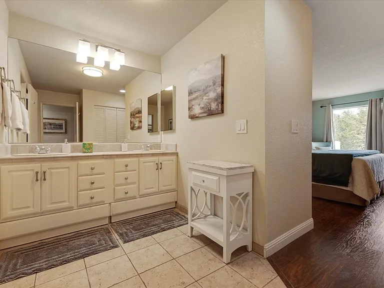 Master bedroom suite bathroom with double sink vanity with full length mirror, hair dryers, 10X magnified pedestal makeup mirror and plenty of storage space. Good lighting and all tile floors and counter. Marble top small vanity with plenty of towels.