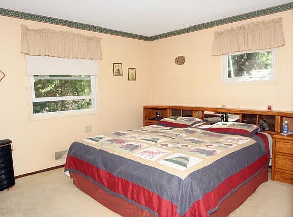 The large master bedroom features neutral carpet and an oversized closet.