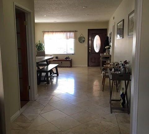 living room w/ doorway on left to office, skylight, front door