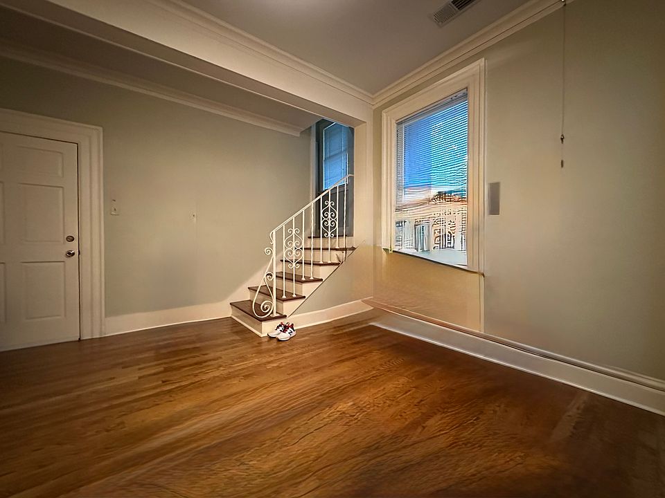 Living room - note deep historic millwork. Stairway to second level which provides private living space or work/studio space and a large bathroom. The 2-level layout is rare and past residents have loved the versatility